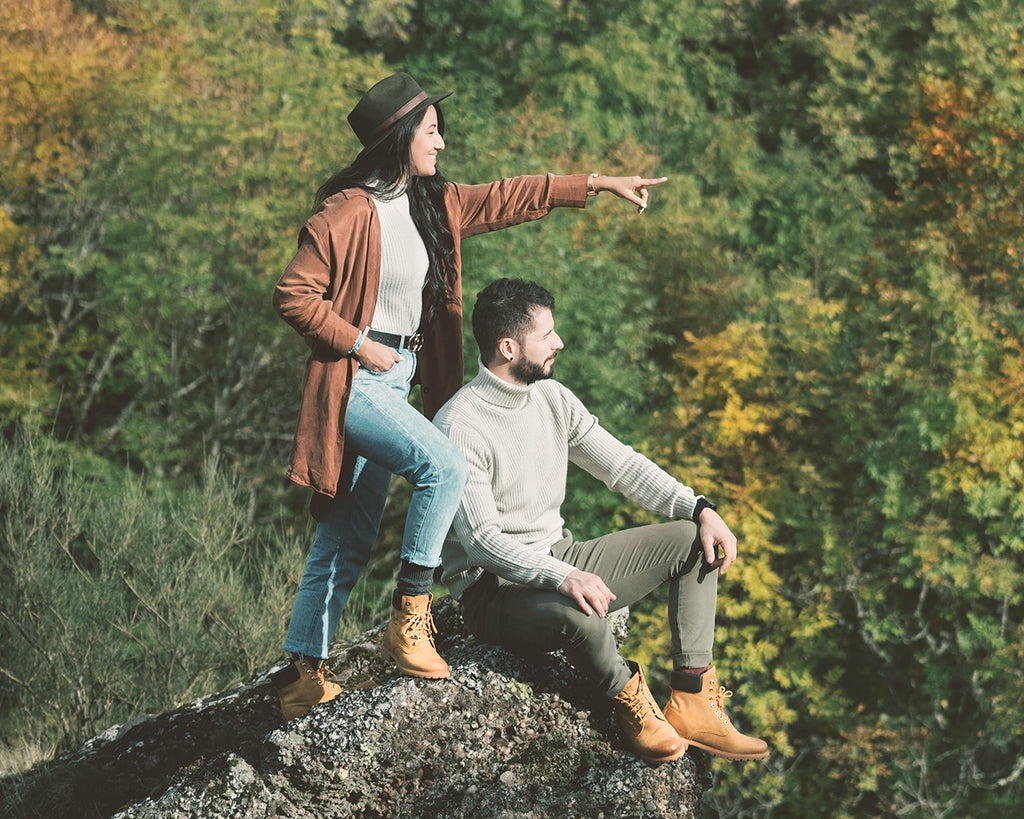 Chico y chica mirando a lo lejos con un bosque en el fondo